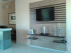 a wall with a flat screen tv on a wall at Hotel Veredas in Três Lagoas