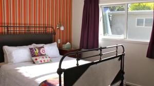 um quarto com uma cama e uma janela em Cottage on Kent em Arrowtown