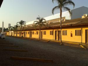 a row of buildings with palm trees on the side of a street at Hotel Veredas in Três Lagoas