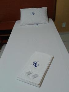 a white bed with two pillows on top of it at Hotel Veredas in Três Lagoas