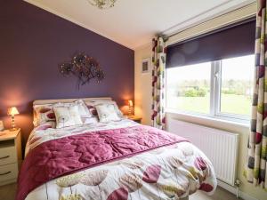 a bedroom with a large bed and a window at Lake View Lodge in Grantham