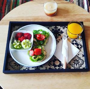 a tray with a plate of food and a glass of orange juice at Urban Yoga House Hostel & Retreat in Ioannina