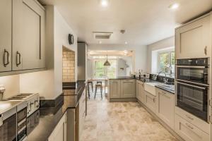 a large kitchen with white cabinets and appliances at Riverside House in Fordingbridge