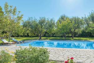 a swimming pool in a yard with a bench and trees at Villa Lilly in Kypseli