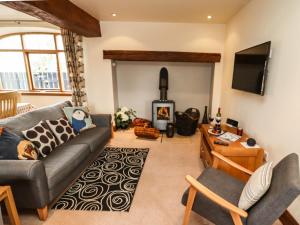 a living room with a couch and a wood stove at Hurdles Cottage in Great Driffield