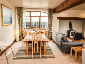 a living room with a table and a couch at Hurdles Cottage in Great Driffield