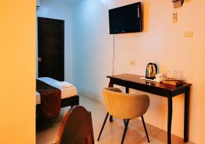 um quarto com uma secretária e um quarto com uma cama em Segra Square Pension House em Balamban