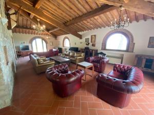 a large living room with leather chairs and tables at Belvilla by OYO Podere San Giovanni ventisei in Chianni