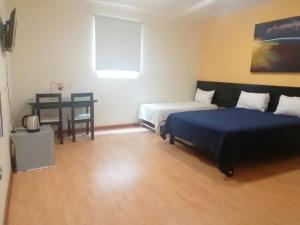 - une chambre avec 2 lits et une table avec une chaise dans l'établissement Miraflores Rooms, à Lima