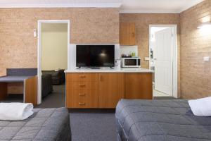 Cedar Lodge Motel في أرميدال: غرفة فندقية بسريرين وتلفزيون بشاشة مسطحة