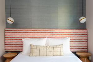 a bed with a red and white striped headboard at Hotel EPIK in San Francisco