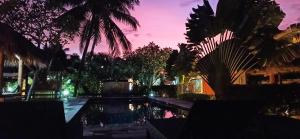 a swimming pool in a yard with palm trees at Mama Bella's Retreat in Senggigi