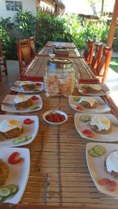 einen langen Holztisch mit Teller Essen drauf in der Unterkunft Mama Bella's Retreat in Senggigi 