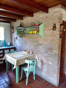 una cucina con tavolo, sedie e muro di mattoni di Las Calandrias a Funes