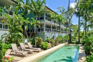 una vista exterior de una casa con piscina y palmeras en Blue Water Views Apartments, en Hamilton Island