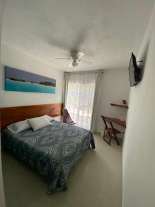 - une chambre avec un lit et un ventilateur de plafond dans l'établissement Gran Jaguar Hotel, à Bacalar
