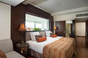 a bedroom with a large bed and a window at Anantara Riverside Bangkok Resort in Bangkok