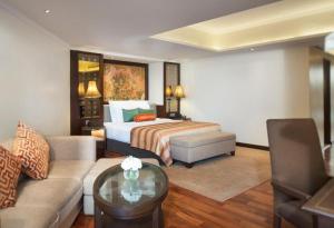 a hotel room with a bed and a couch at Anantara Riverside Bangkok Resort in Bangkok