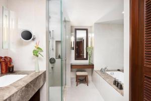 a bathroom with a glass shower and a sink at Anantara Riverside Bangkok Resort in Bangkok