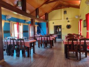 a dining room with tables and chairs in a restaurant at Hotel Burans & Restaurant in Chakrāta
