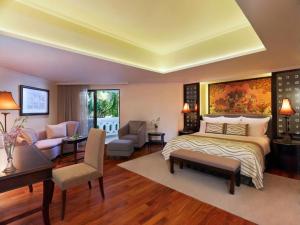 a bedroom with a bed and a living room at Anantara Riverside Bangkok Resort in Bangkok