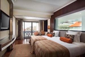 a hotel room with two beds and a large window at Anantara Riverside Bangkok Resort in Bangkok