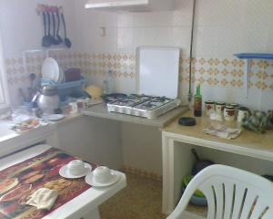 a small kitchen with a stove and a table at Excellente Appartement Entre Monastir Et Sousse in Sahline