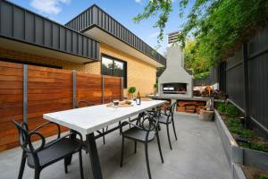 a patio with a white table and chairs and a grill at Comfort & Style - Luxurious Central Apartment in Albury