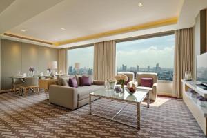 a living room with a couch and a table at Avani Plus Riverside Bangkok Hotel in Bangkok