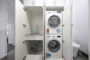 a bathroom with a washing machine and a sink at Comfort & Style - Luxurious Central Apartment in Albury