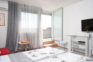 a white room with a large window and a table with fruit at Apartments Asja- city view in Zagreb