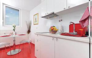 a kitchen with white cabinets and a red floor at Apartments Asja- city view in Zagreb