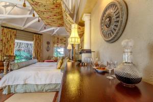 a bedroom with a bed and a table with glasses on it at Blue Mountain Luxury Lodge in Hazyview