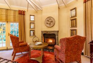 a living room with a fireplace and a table and chairs at Blue Mountain Luxury Lodge in Hazyview
