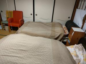 秩父市にあるきっとあい楽館のベッド2台と椅子が備わる客室です。