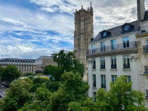 um edifício com uma torre de relógio numa cidade em Stunning apartment with view at the very heart of Paris em Paris