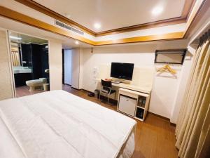 ein Hotelzimmer mit großem Bett und Schreibtisch in der Unterkunft Spring Art Hotel in Kaohsiung
