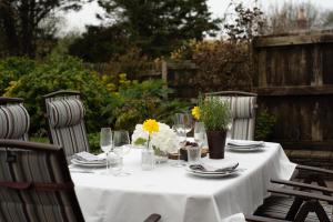 ポート・アイザックにあるSwallow Cottageの白いテーブルクロスと花のテーブル
