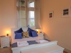 a bedroom with a white bed with blue pillows at Rydal Suite in Ambleside