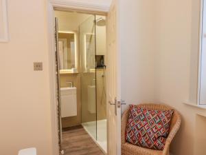 a bathroom with a chair and a glass shower door at Rydal Suite in Ambleside +27 photos
