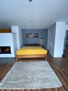 a bedroom with a yellow bed and a fireplace at Ferienwohnung 2 Schweizer in Geisingen