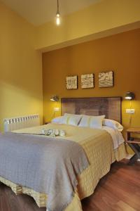 - une chambre avec un grand lit aux murs jaunes dans l'établissement Infanta Isabel, à Arévalo