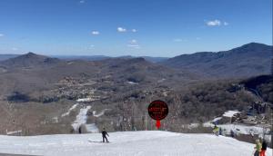 シュガー・マウンテンにあるAPPresSki - 5 bed Ski in Ski out - 50 Steps to Ski Sugar Mountain Slopesの雪山をスキーで下りている人