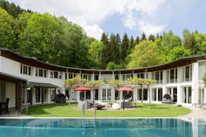 an exterior view of a building with a swimming pool at Designferienhaus Privat Villa+ Pool+ Park+ Sport in Micheldorf