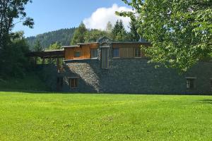 a large house with a grass field in front of it at Designferienhaus Privat Villa+ Pool+ Park+ Sport in Micheldorf