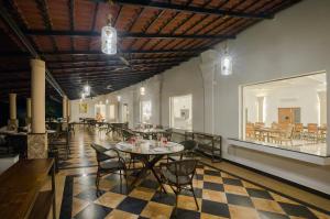 a restaurant with tables and chairs and a checkered floor at TULI VEER BAGH RESORT TURIA in Khawāsa