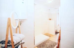 ein weißes Bad mit einem Spiegel und einer Dusche in der Unterkunft Ferienwohnung Prinz Heinrich in Quedlinburg