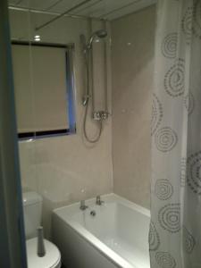 een badkamer met een bad, een toilet en een douche bij Lavender Cottage with Parking and Beautiful Views in Carsphairn