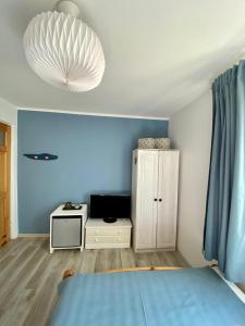 ウェバにあるPokoje gościnne EWELAの青い壁のベッドルーム1室、ベッド1台、キャビネットが備わります。