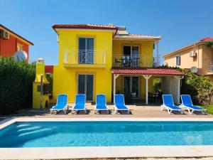 un gruppo di sedie e una piscina di fronte a una casa di Iridia Resort Villas a Foiníki